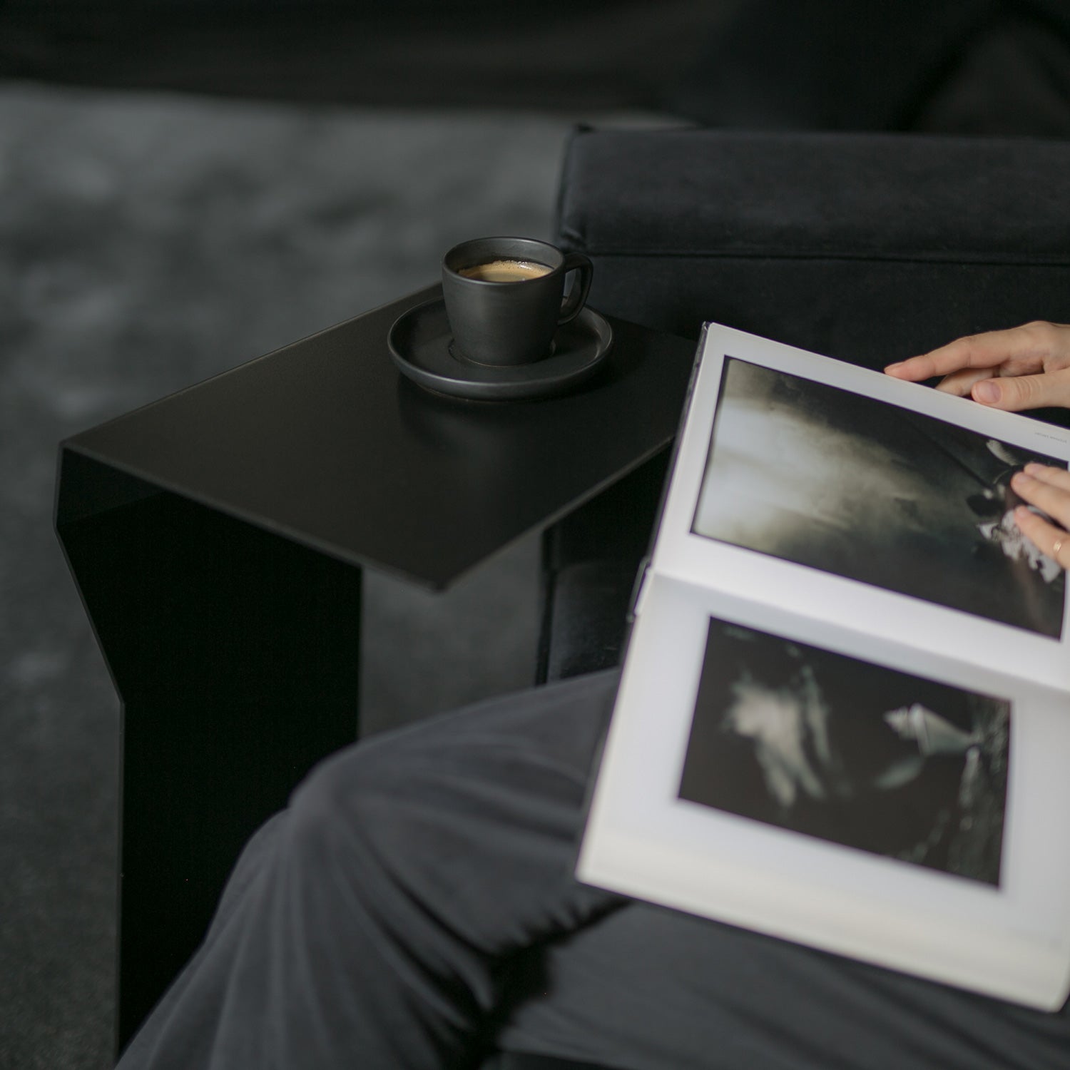 Close-up of black side table details in dark, moody interior