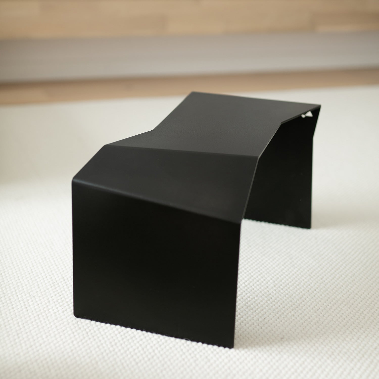 Minimalist black table shown from behind in alternate configuration