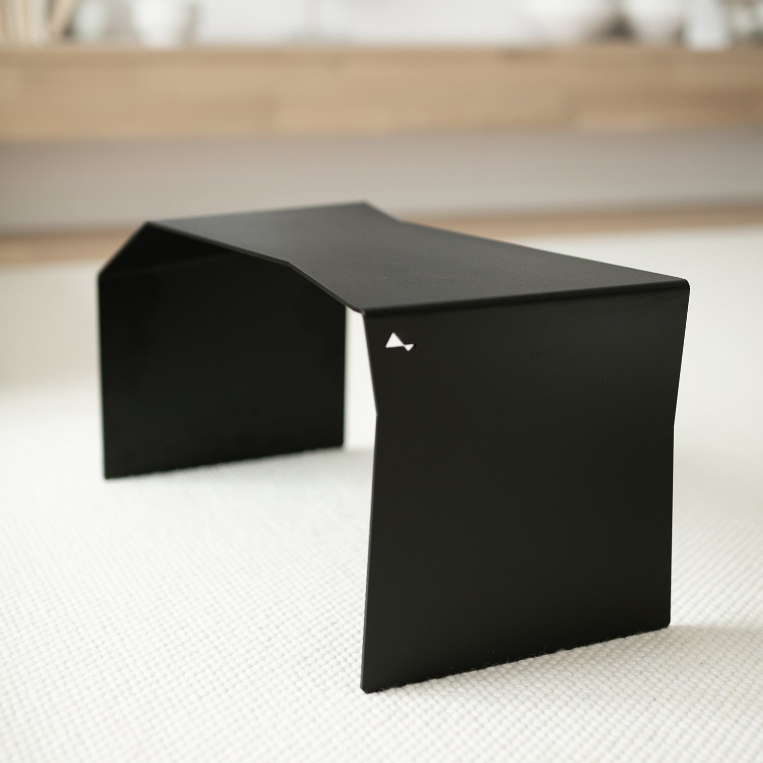 Modern black side table in inverted position functioning as coffee table