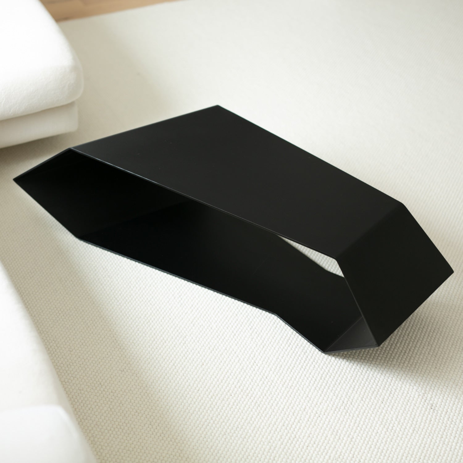 Black modern metal coffee table on a cream carpet