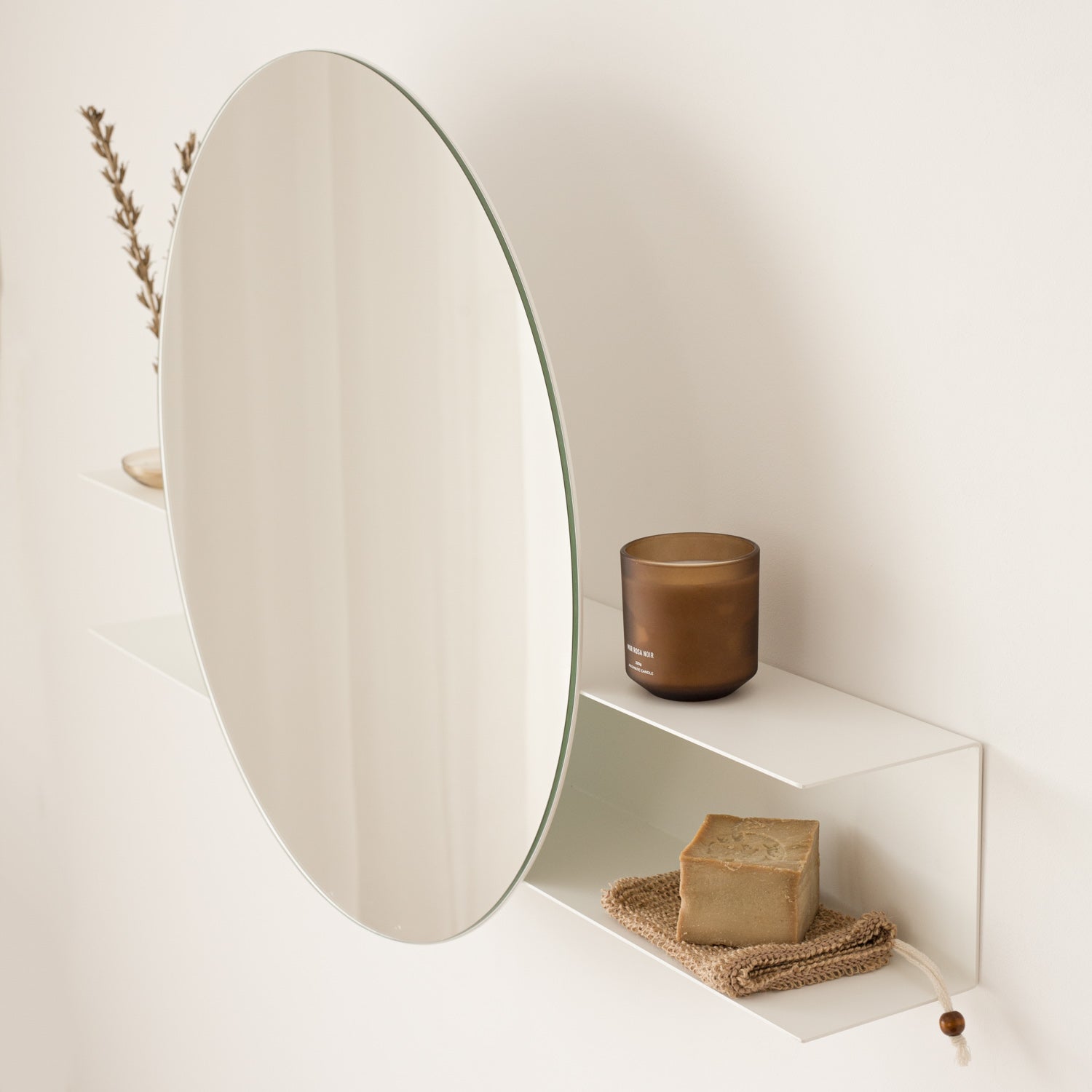 White arust free round mirror with shelf on white wall