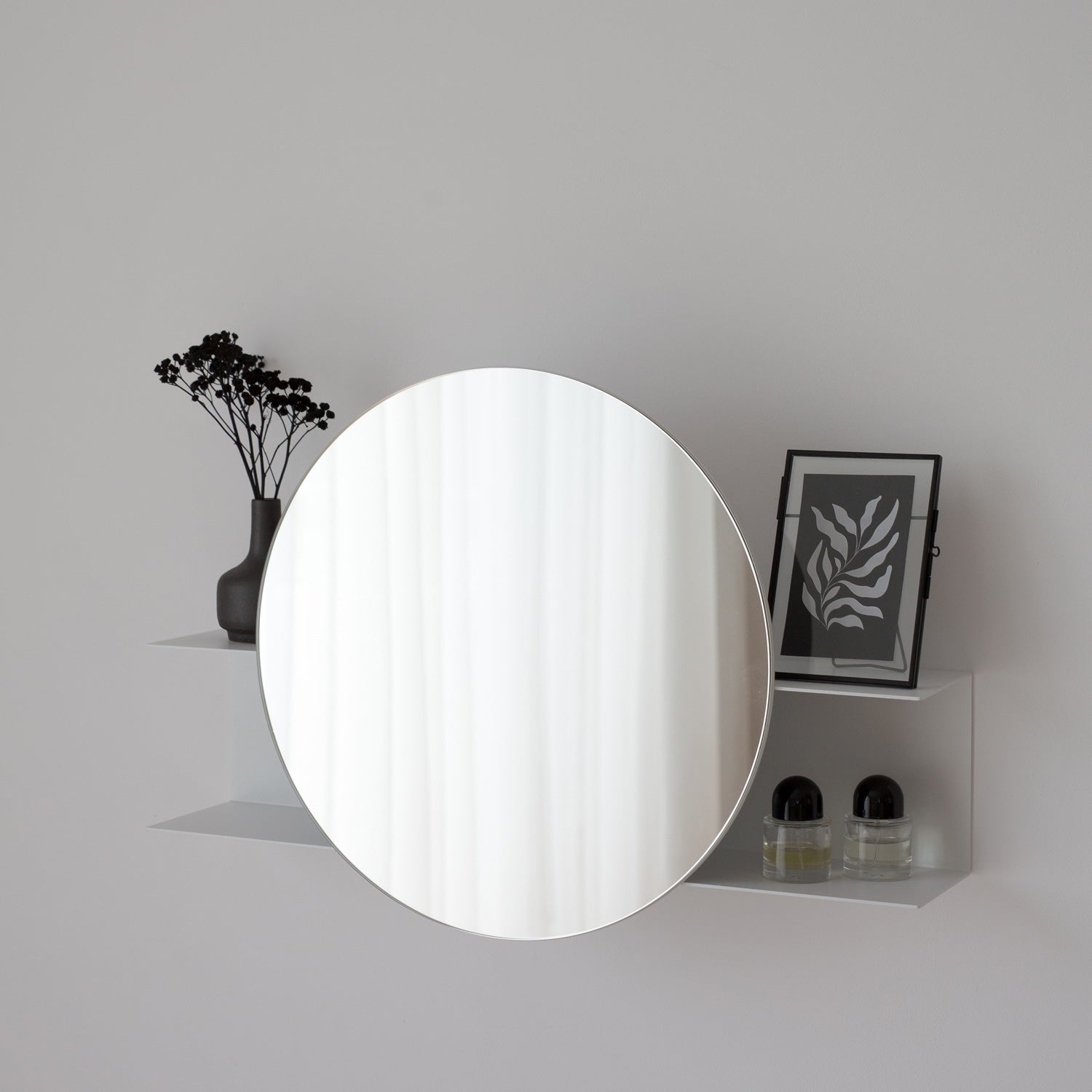White small round mirror on a gray background with minimal decor