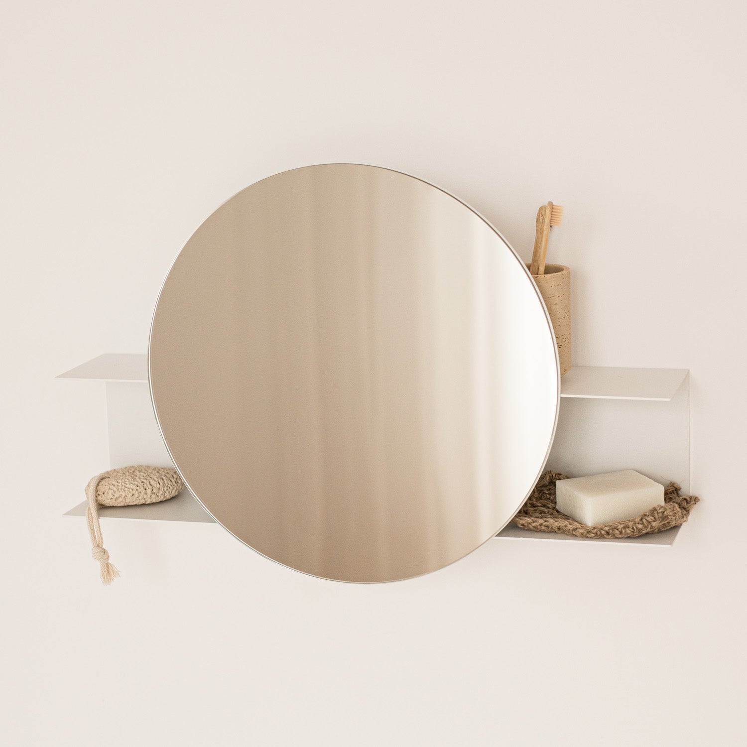 white small round wall mirror with a shelf