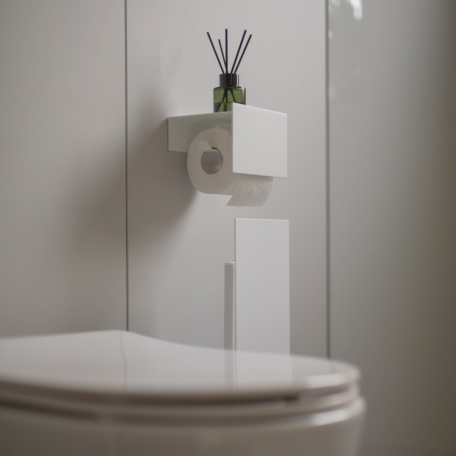 white toilet paper roll holder in grey bathroom