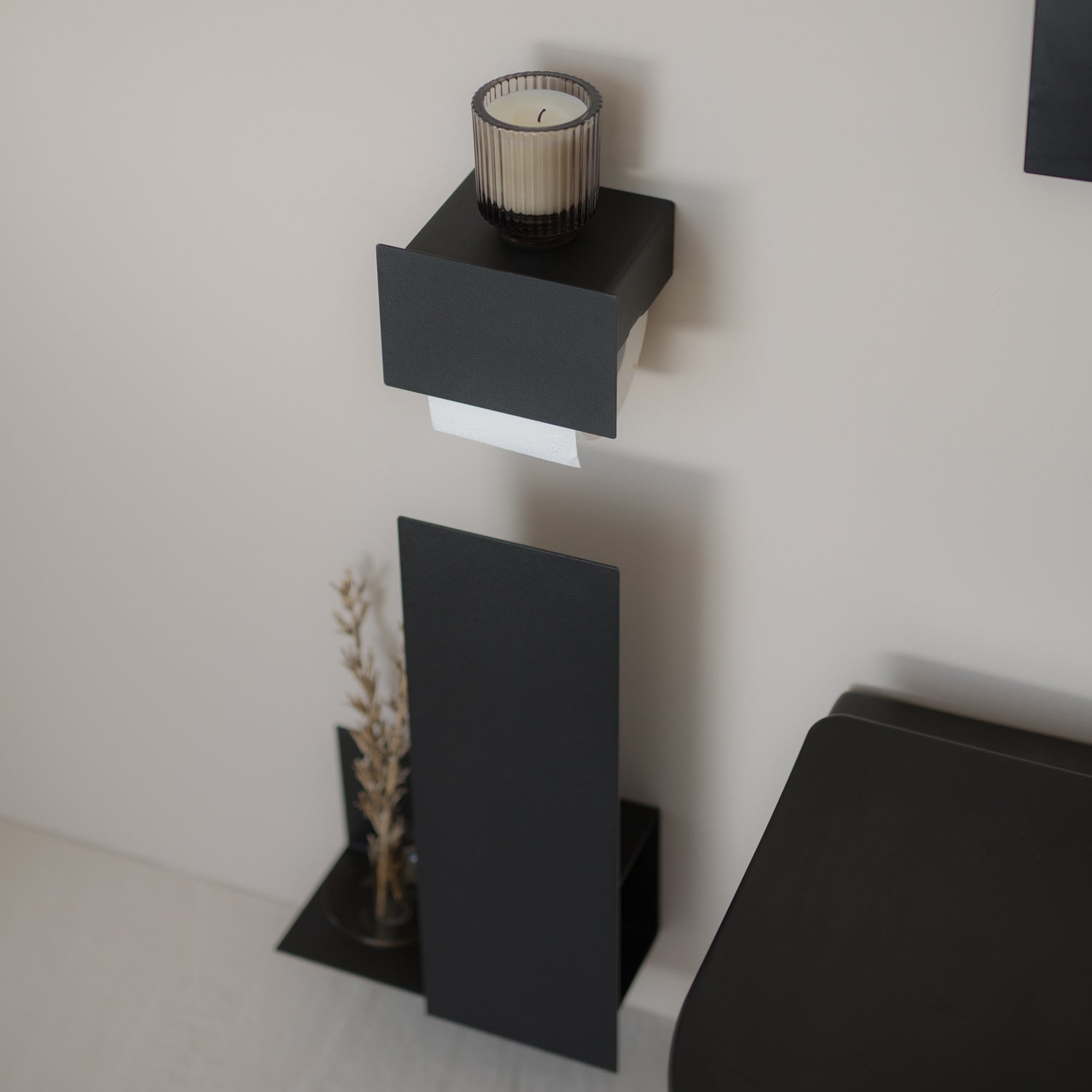Black wall-mounted toilet set with a storage shelf tape mounted