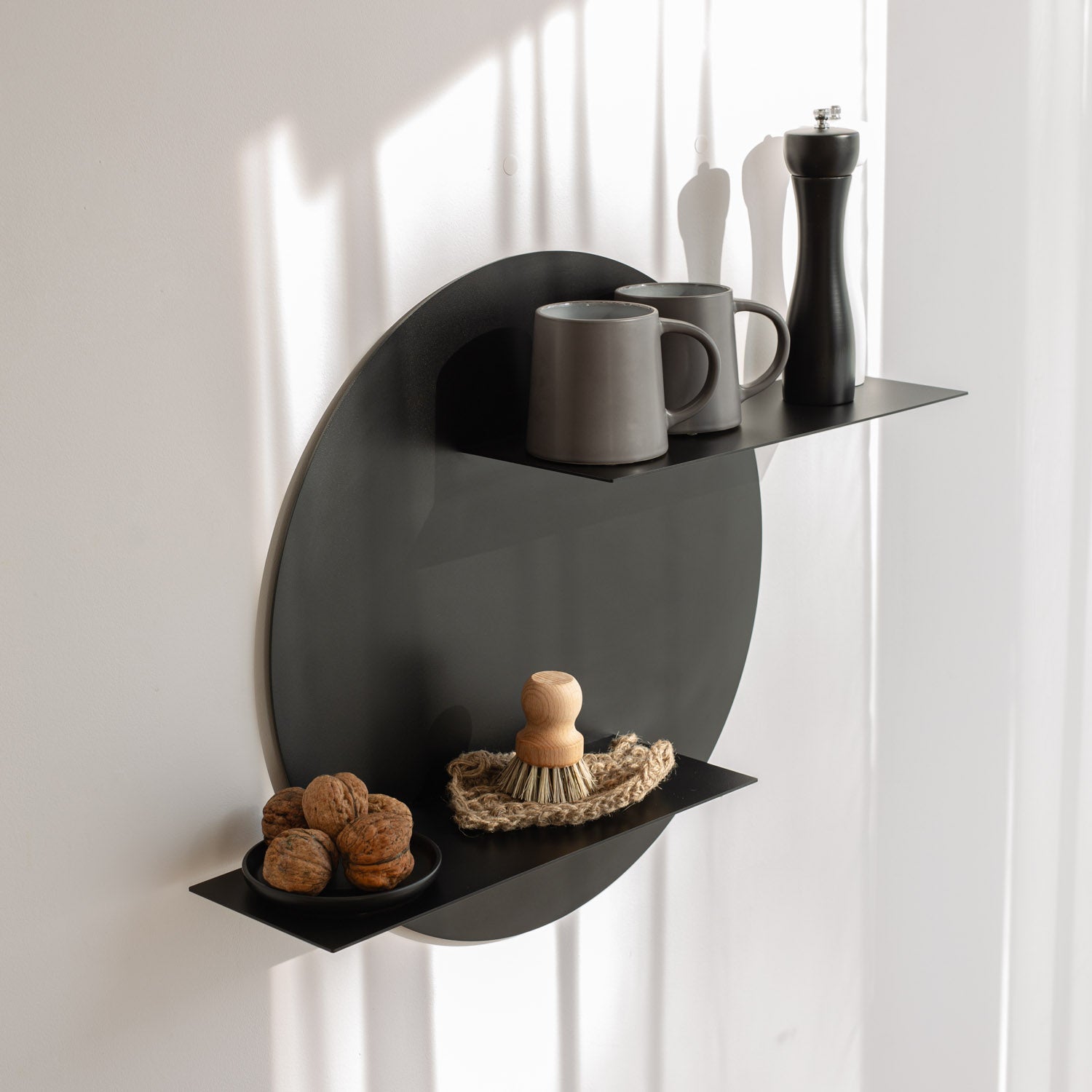 Black wall-mounted shelf with decorative items against a white curtain background