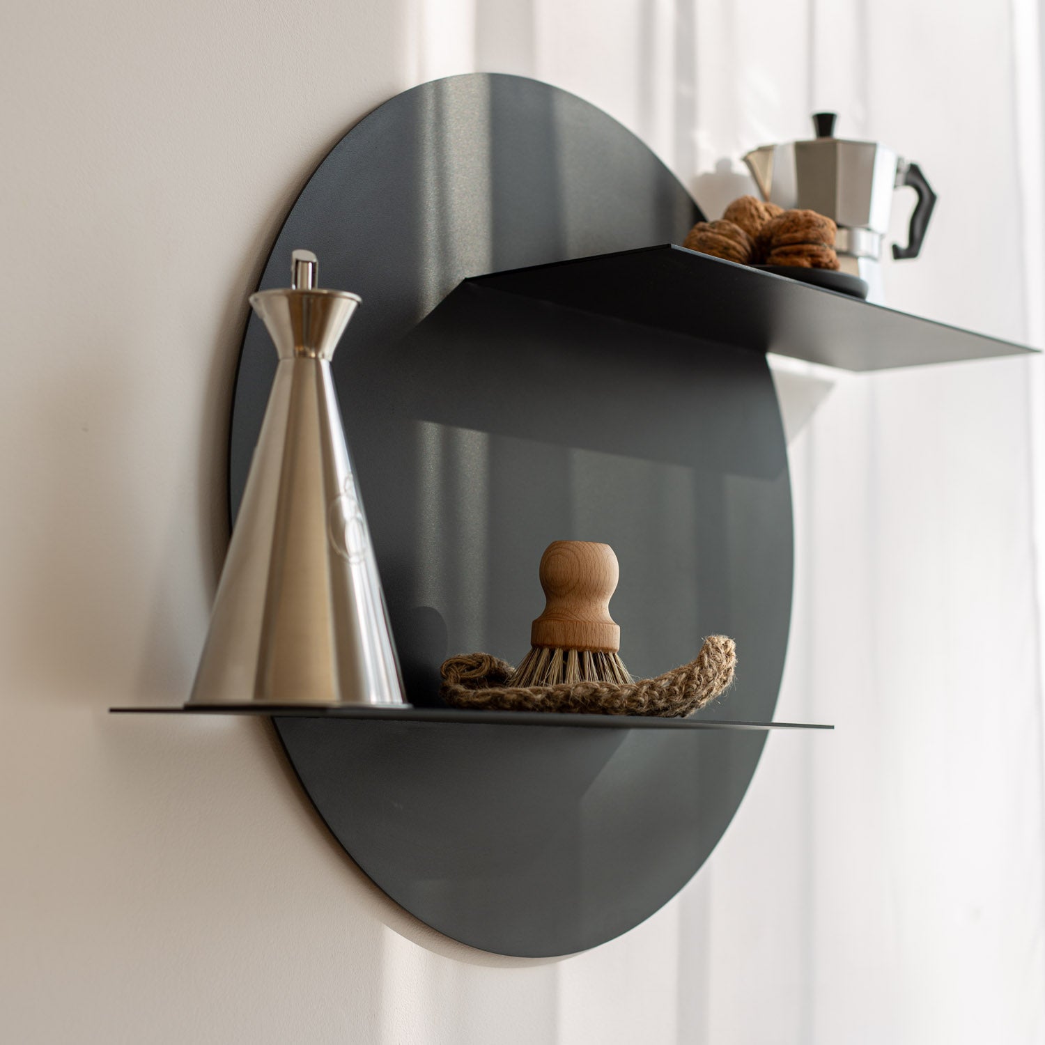 Modern black kitchen wall-mounted shelf with decorative items against a white curtain background