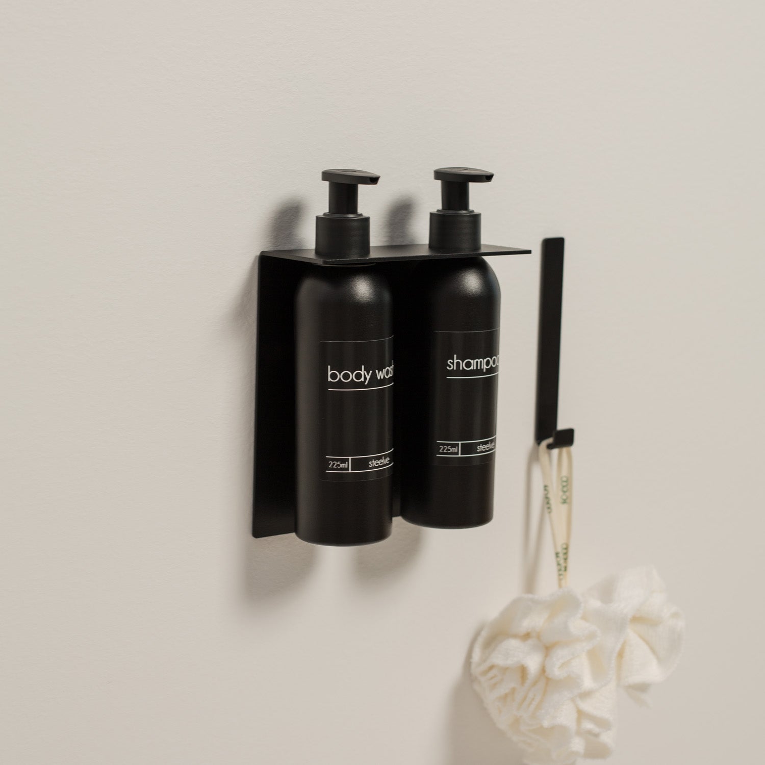 Black shampoo and body wash dispeners on a wall