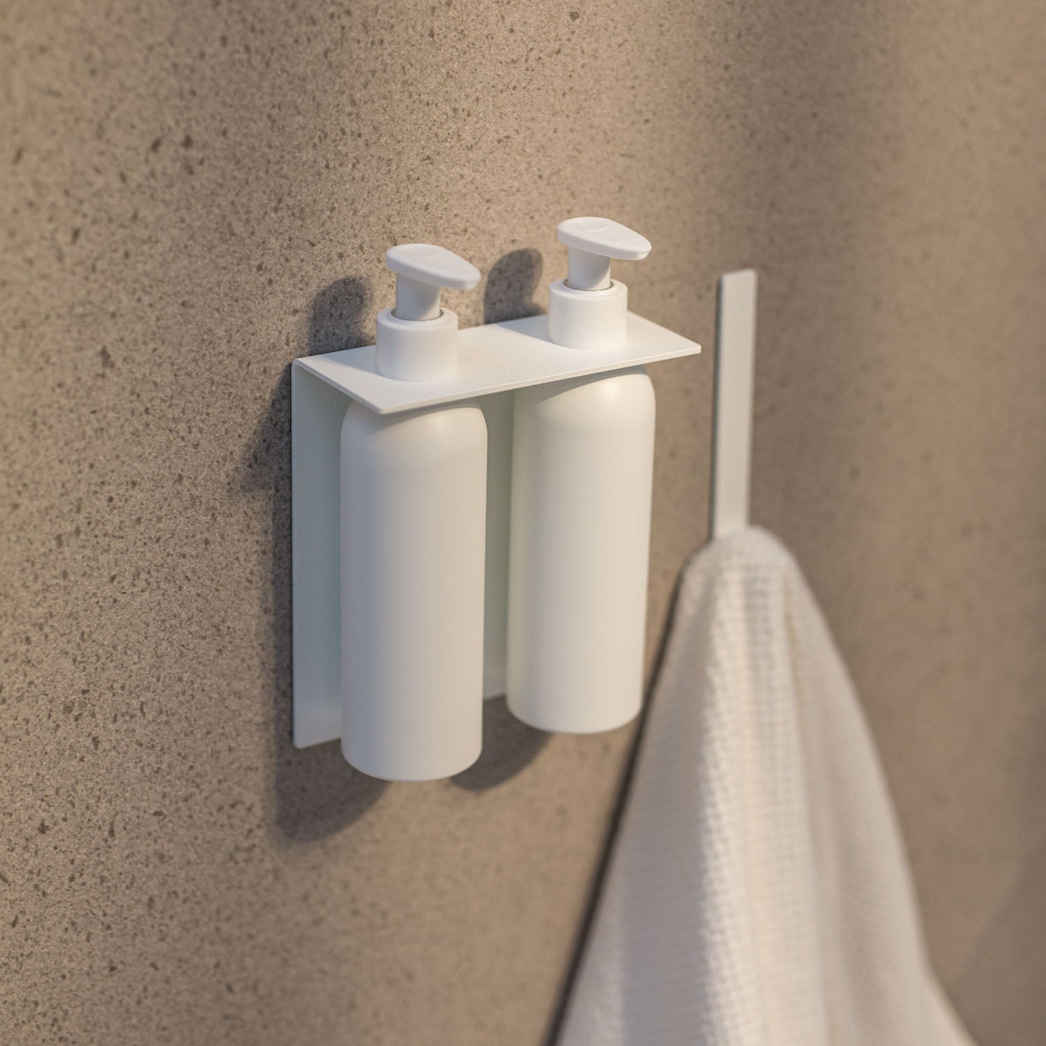 White wall-mounted soap dispenser with a towel on a textured wall