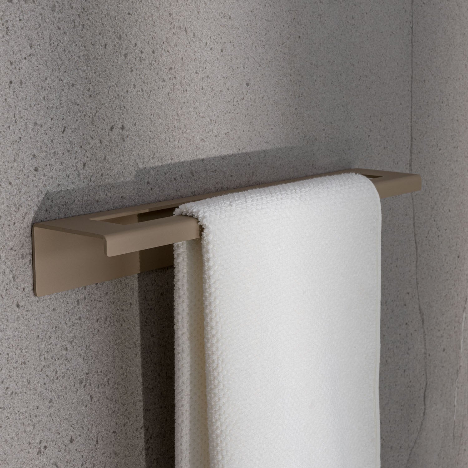 Minimalist beige towel rack with a white towel on a gray wall