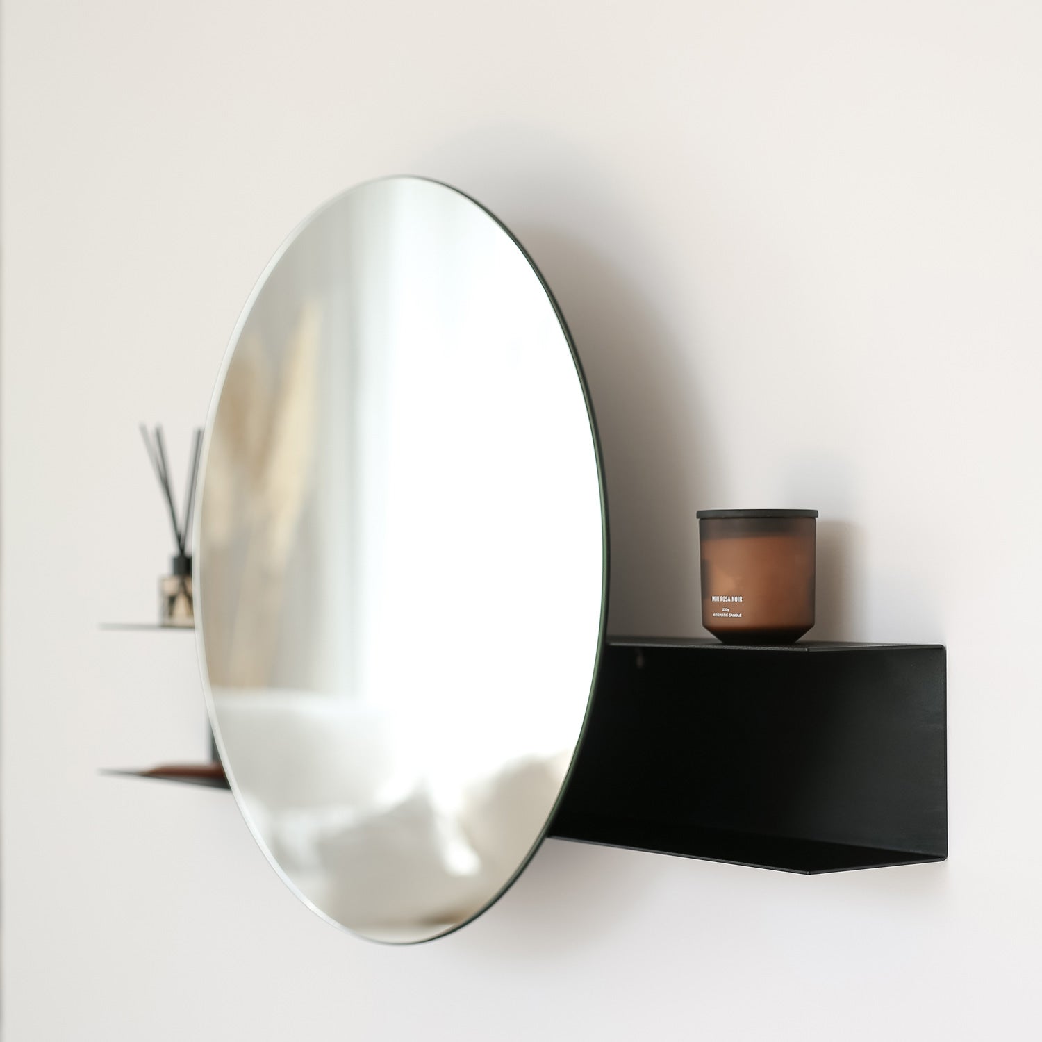 Black contemporary round wall mirror on white wall