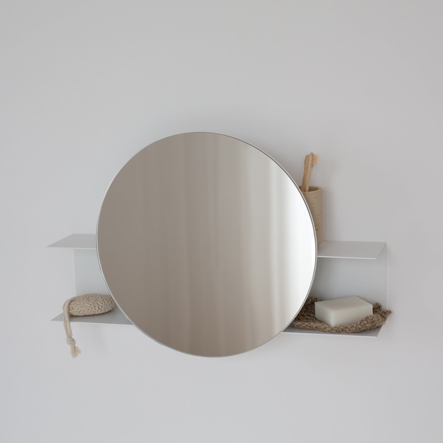 modern round bathroom mirror on a white wall with minimal decor
