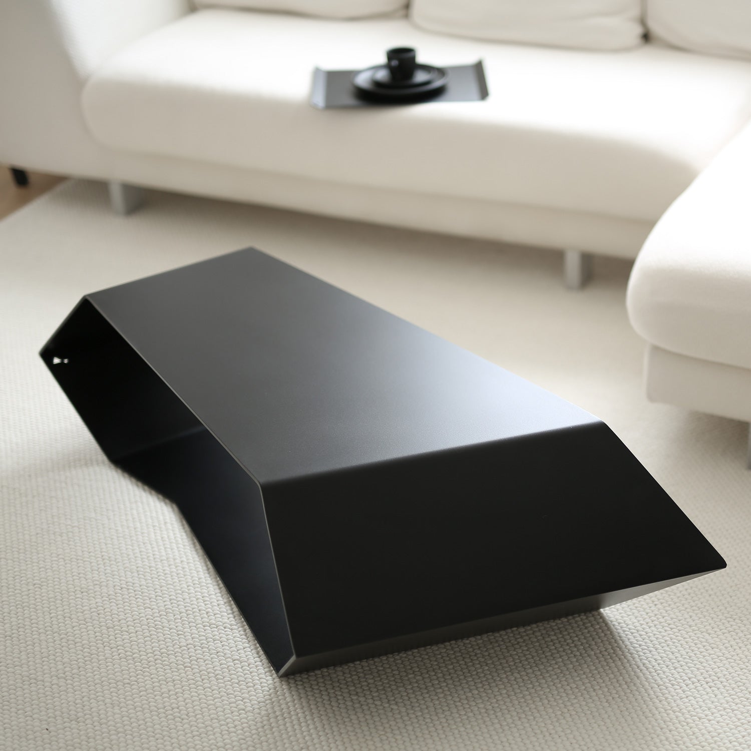 black designer coffee table in modern interior with cream decoration 