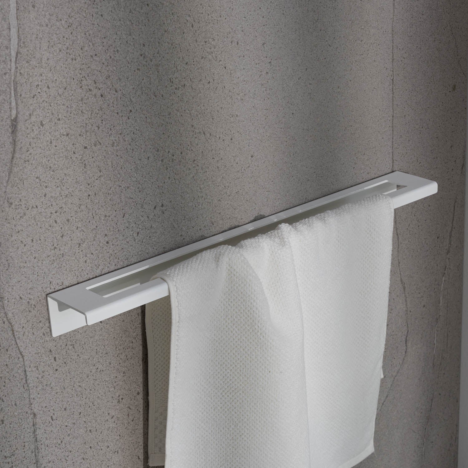 Large white Towel rack with a white towel on a gray wall